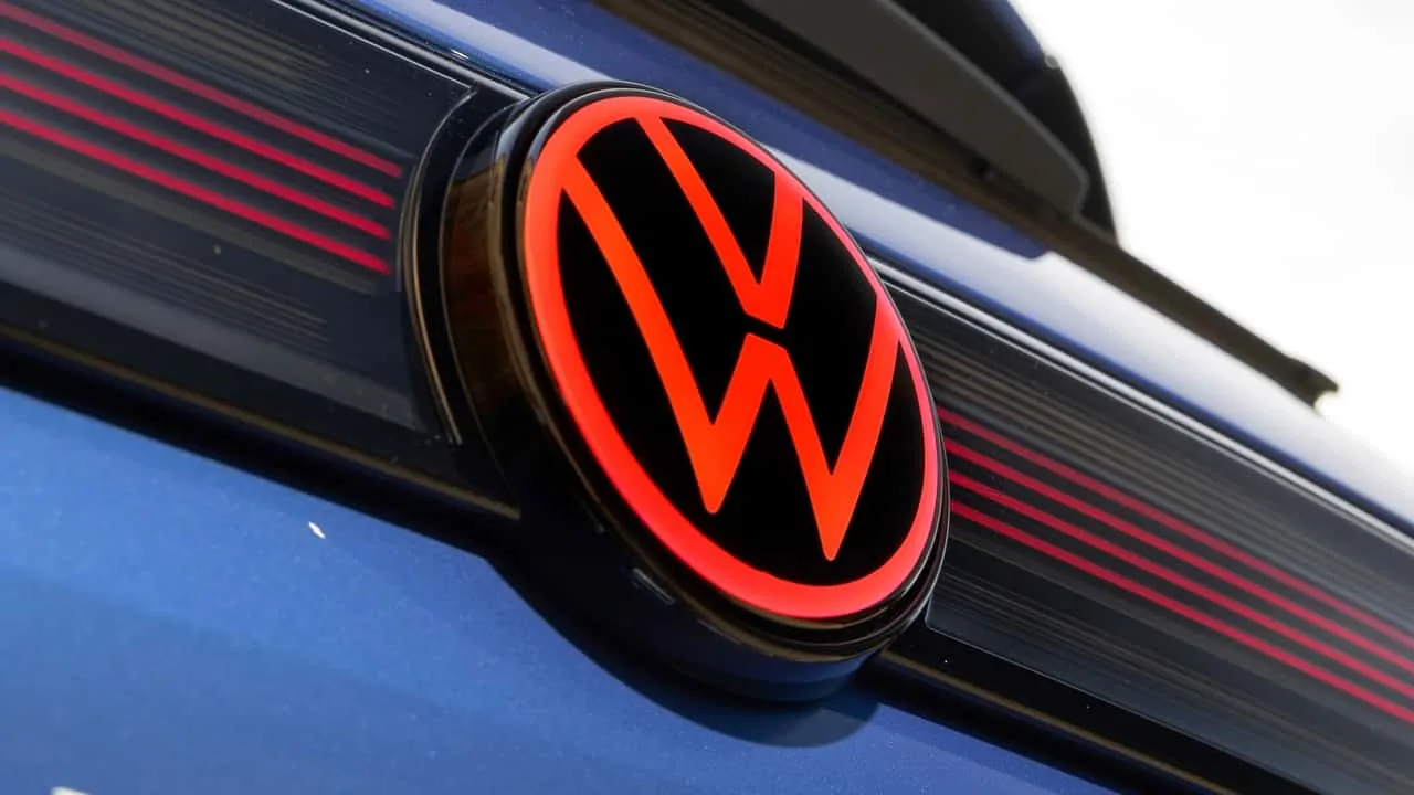 Volkswagen illuminated badge on a vehicle against a dark background